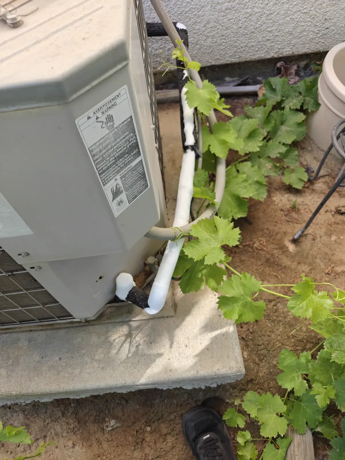 Outdoor AC condenser has an iced-up suction line due to low refrigerant charge